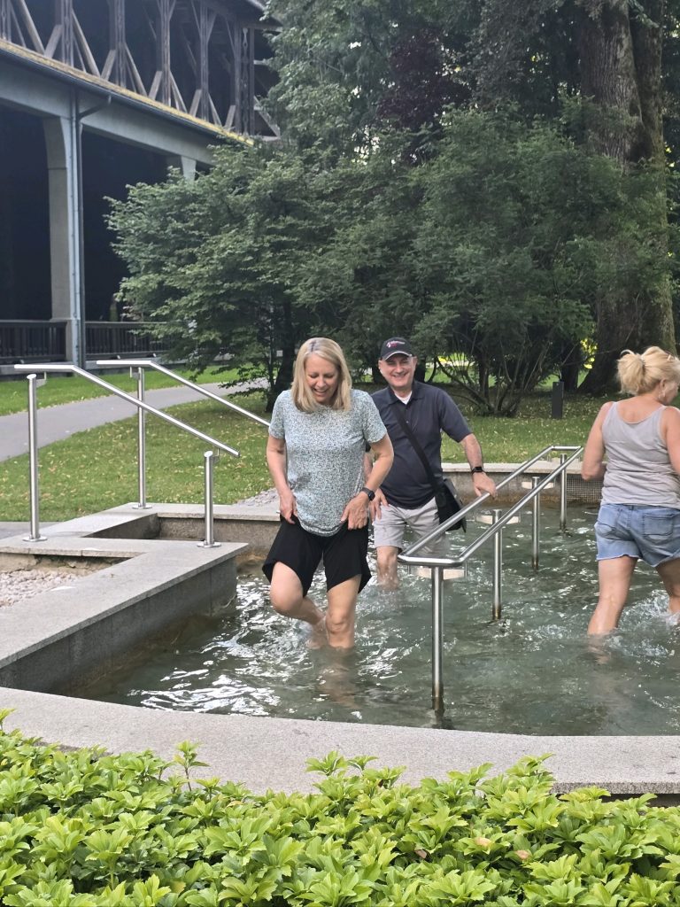 A man and a woman wading through a cement pond